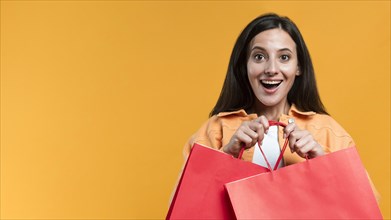 Excited woman holding shopping bags with