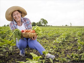 Woman holding basket full vegetables with copy space