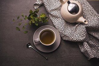 Elevated view tea leaves teapot polka dotted textile table