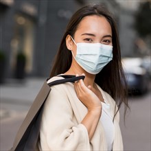 Woman with medical mask out sale shopping spree with shopping bag