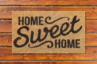 Overhead of home sweet home doormat on the wood plank porch