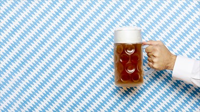 Man holding beer pint with patterned background