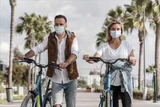 People riding bike while wearing medical mask