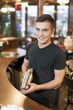 Smiling man with cocktail shaker