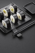 High angle sushi rolls with chopsticks sauce