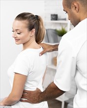 Male physiotherapist checking woman s back pain