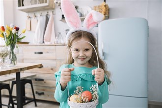 Girl bunny ears holding basket with easter eggs