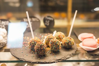Chocolate cake pops with colorful sprinkles display cabinet
