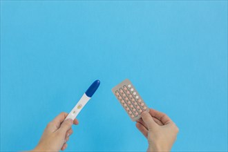 Hand holding contraceptive pills pregnancy test