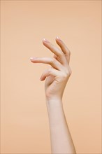 Sideview woman s hand pale orange background