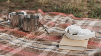Camping outdoors with book mugs hot drinks