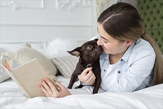 Close up girl reading bed with cute dog