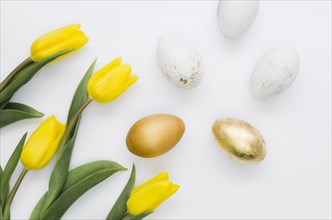 Flat lay golden easter eggs with flowers