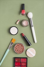 High angle view various makeup products green background