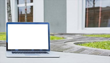 Laptop with blank screen front house
