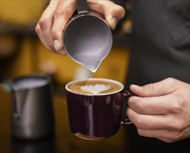 Front view male barista pouring coffee cup