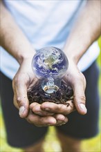 Concept hands holding earth bulb