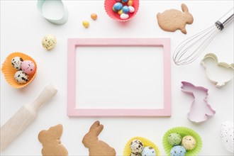 Top view frame with easter bunny cookies kitchen utensils