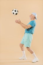 Modern senior man with football