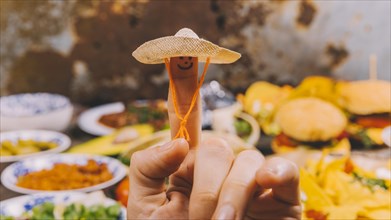 Close up finger art with small hat mexican food background
