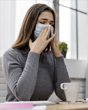 Woman wearing face mask while working from home