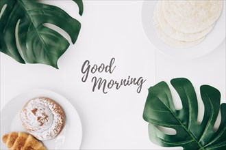 Fresh flour tortillas baked bun croissant breakfast with good morning text paper green monster leaves white background