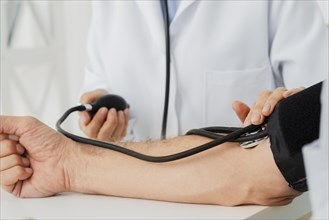 Close up doctor inflating blood pressure cuff