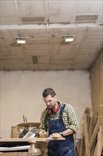 Professional male carpenter taking measurement workbench workshop