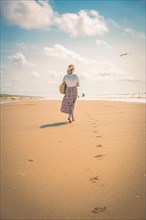 Tourist barefoot with skirt on sandy beach