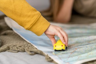 Child playing with car toy map