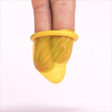 Close up fingers yellow condom