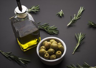 Olives olive oil rosemary black slate surface