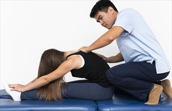 Physiotherapist massaging woman s upper back pain