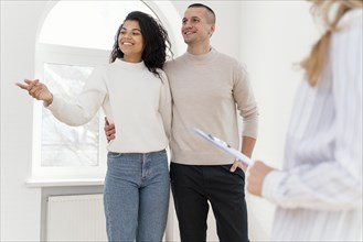 Smiley couple seeing new house with realtor
