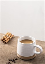 High angle coffee mug with cinnamon sticks copy space