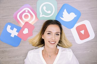 Portrait smiling woman standing front wall with social networking icons