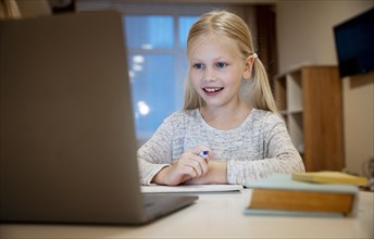 Girl doing her homework laptop concept