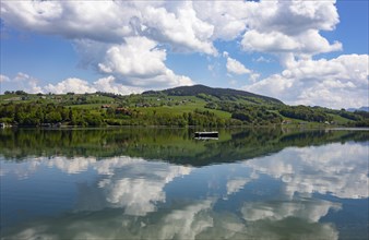 (Cumulus) clouds with fishing boat reflected in the Irrsee, Zell am moss, Salzkammergut, Upper