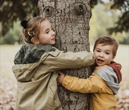 Medium shot kids hugging tree