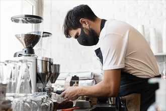 Medium shot barista wearing mask