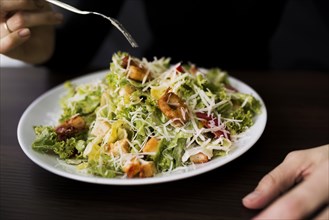Person eating tasty caesar salad with croutons restaurant