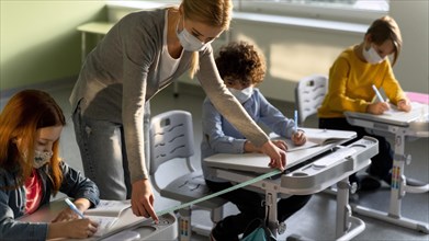 Teacher measuring social distance school benches during pandemic