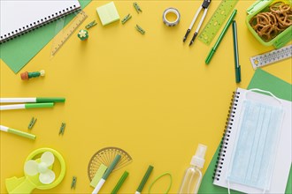 Flat lay back school materials with notebook face mask