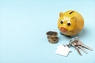 Yellow piggy bank with keys copy space background