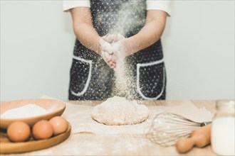 Woman making bread pouring flour