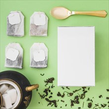Different type herbal tea bags sugar cubes spoon white box colored background