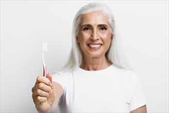 Smiley mature woman proud her toothbrush