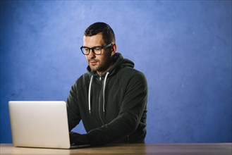 Hacker with glasses looking laptop