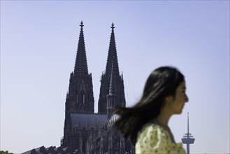 Silhouette of passer-by on the Rhine promenade in front of Cologne Cathedral
