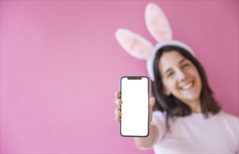 Woman bunny ears holding smartphone with blank screen
